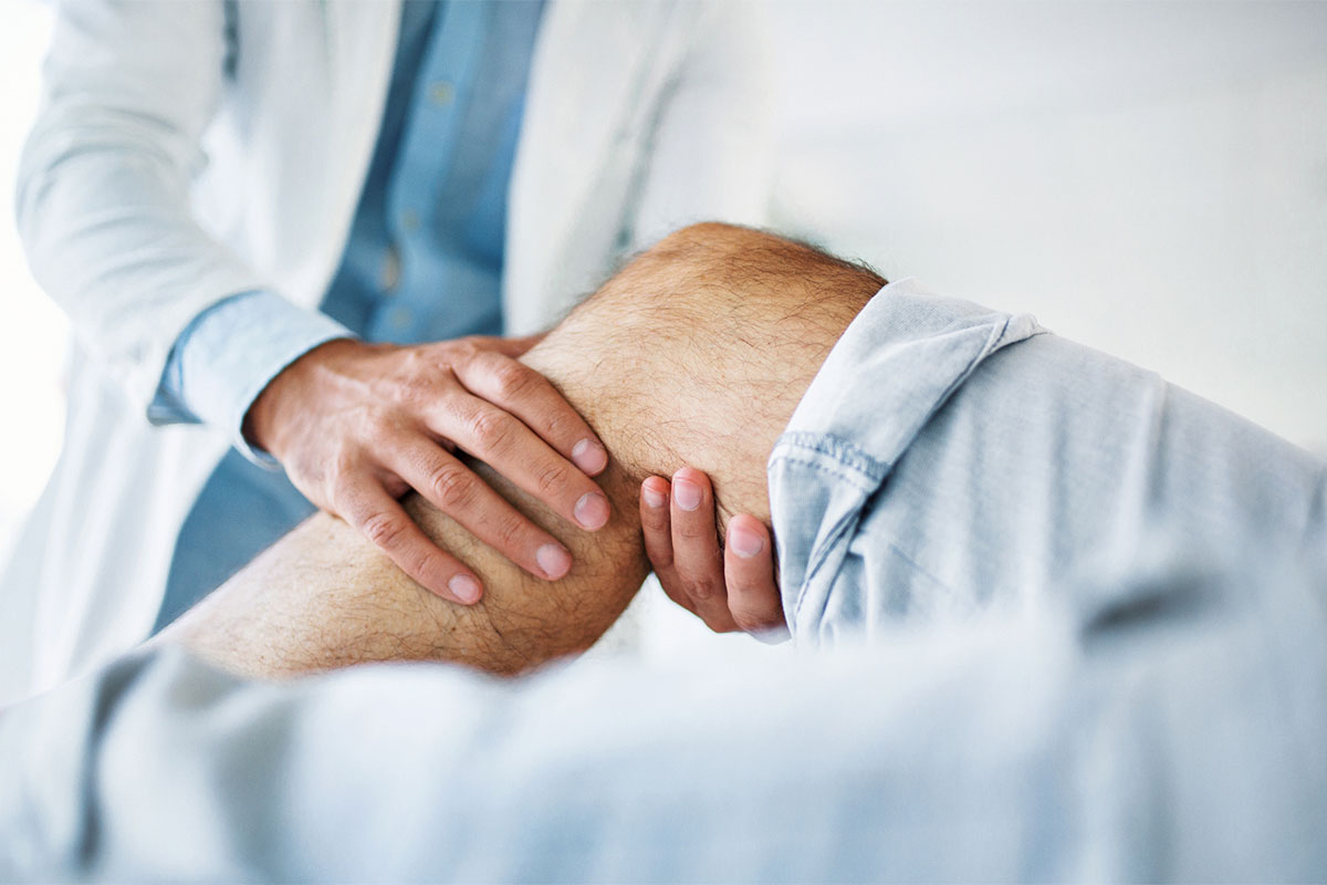 Orthopedic doctor examining a patient’s knee for pain or injury